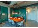 Chic dining area with a wooden table, modern chairs, and bold teal accent wall in a loft-style condo at 10 N Summerlin Ave # 55, Orlando, FL 32801