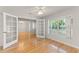 Bright living room with wood floors, ceiling fan, and view of the front yard through a large window at 1019 Spring Landing Dr, Winter Garden, FL 34787