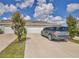 View of home showcasing the garage, driveway, landscaping and a parked SUV on a sunny day at 11038 Leafshore Loop, Orlando, FL 32829