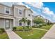 Well-kept townhome showcasing manicured lawn and tidy landscaping under a blue sky at 11038 Leafshore Loop, Orlando, FL 32829