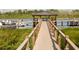 Scenic dock with a covered gazebo overlooking a serene lake with boats, perfect for relaxation and enjoying waterfront views at 14501 Grove Resort Ave # 1229, Winter Garden, FL 34787