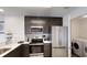 Modern kitchen featuring stainless steel appliances and ample cabinet space, next to laundry area at 14501 Grove Resort Ave # 1229, Winter Garden, FL 34787