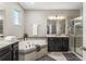 Luxurious bathroom with a corner soaking tub, separate shower, and dark wood cabinetry for a spa-like experience at 14661 Glade Hill Park Way, Winter Garden, FL 34787