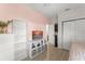 Bright bedroom features a pink accent wall, laminate flooring, and white shelving providing ample storage at 14661 Glade Hill Park Way, Winter Garden, FL 34787