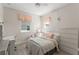 Bright bedroom with wood-look flooring, two windows with charming curtains, and a white desk and dresser at 14661 Glade Hill Park Way, Winter Garden, FL 34787