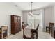 Dining room featuring a wooden table, modern lighting fixture, and large window offering natural light at 14661 Glade Hill Park Way, Winter Garden, FL 34787