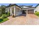 Home exterior featuring a brick driveway, two-car garage, and well-manicured landscaping at 14661 Glade Hill Park Way, Winter Garden, FL 34787