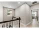 Well-lit hallway with hardwood floors, a window, and an open doorway leading to another room at 14661 Glade Hill Park Way, Winter Garden, FL 34787