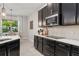 Modern kitchen features dark cabinets, white countertops, tile backsplash and stainless steel appliances at 14661 Glade Hill Park Way, Winter Garden, FL 34787