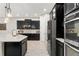 Modern kitchen with dark cabinetry, stainless steel appliances, and a quartz island, perfect for cooking at 14661 Glade Hill Park Way, Winter Garden, FL 34787