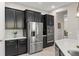 Stylish kitchen featuring stainless steel refrigerator and appliances, dark cabinets, and sleek countertop at 14661 Glade Hill Park Way, Winter Garden, FL 34787