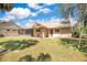 View of the backyard featuring a screened in porch, a grassy yard with mature trees and tan siding at 1912 Abbington St # Ge, Apopka, FL 32712