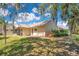 Exterior view of the home featuring mature trees, mulch bed, lush green grass, and screened in porch at 1912 Abbington St # Ge, Apopka, FL 32712