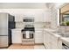 Functional kitchen with white cabinets, stainless steel appliances, and a bright window at 1912 Abbington St # Ge, Apopka, FL 32712