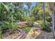 Beautiful backyard featuring a wooden deck, lush landscaping, and a stone pathway at 1923 Osman Ave, Orlando, FL 32806