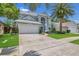 Charming two-story home with a well-manicured lawn, beautiful landscaping, and a large palm tree at 1923 Osman Ave, Orlando, FL 32806