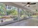 Bright sunroom with tile flooring, ceiling fans, and views of backyard garden and fountain at 1923 Osman Ave, Orlando, FL 32806