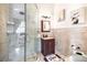 Bathroom with walk-in shower, stone wall tile, vanity and dark wood cabinets at 1984 Windermere Rd, Windermere, FL 34786