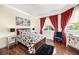 Bedroom with hardwood floors, decorative rug, window, queen bed, two side tables and lamps at 1984 Windermere Rd, Windermere, FL 34786