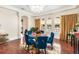 Bright dining room with wood floors, blue velvet chairs, and large windows for natural light at 1984 Windermere Rd, Windermere, FL 34786