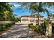 Elegant two-story home featuring a grand entrance, manicured landscaping, brick driveway, and a beautiful palm tree at 1984 Windermere Rd, Windermere, FL 34786