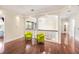 Bright hallway with hardwood floors, chandelier, railing, arches, and two green chairs at 1984 Windermere Rd, Windermere, FL 34786