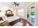 Bright bedroom featuring hardwood floors, a ceiling fan, and direct pool access at 1984 Windermere Rd, Windermere, FL 34786