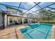 A large screened-in pool with an attached spa and brick paver decking at 1984 Windermere Rd, Windermere, FL 34786