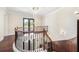 Elegant curved staircase with hardwood floors, iron railings and a decorative chandelier at 1984 Windermere Rd, Windermere, FL 34786