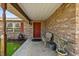 Covered brick porch with a chair and plants, welcoming entrance with a red front door at 2010 Overlook Dr, Winter Haven, FL 33884