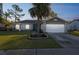 Charming single-story home with a well-manicured lawn and inviting blue front door at dusk at 2242 Dancy Trl, Clermont, FL 34714