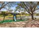 Backyard featuring a playground, mature trees, a white picket fence, and access to a lake at 2315 Cypress Trace Cir, Orlando, FL 32825