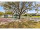 Backyard featuring a playground, mature trees, a white picket fence, and a lake at 2315 Cypress Trace Cir, Orlando, FL 32825