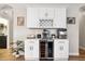 Modern coffee bar area with white cabinets, wine refrigerator, backsplash, and updated decor at 2315 Cypress Trace Cir, Orlando, FL 32825