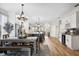 Open-concept dining room with wooden table, bench seating, elegant chandelier, and adjacent kitchen and living areas at 2315 Cypress Trace Cir, Orlando, FL 32825