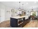 Kitchen island with seating, stainless steel appliances, hardwood floors, and views of the dining and living areas at 2315 Cypress Trace Cir, Orlando, FL 32825