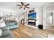 Bright living room featuring a modern fireplace, hardwood floors, a ceiling fan, and an open concept to the dining and kitchen area at 2315 Cypress Trace Cir, Orlando, FL 32825