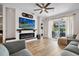 Bright living room featuring a modern fireplace, hardwood floors, a ceiling fan, and a sliding glass door to the outdoors at 2315 Cypress Trace Cir, Orlando, FL 32825