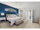 Serene main bedroom featuring a navy accent wall, arched window, ceiling fan, and neutral decor at 2315 Cypress Trace Cir, Orlando, FL 32825