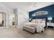 Main bedroom featuring a navy accent wall, arched window, ceiling fan, and ensuite bathroom access at 2315 Cypress Trace Cir, Orlando, FL 32825