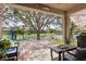 Covered patio with brick flooring overlooking fenced yard and playground with lake view at 2315 Cypress Trace Cir, Orlando, FL 32825