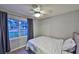 Serene bedroom showcasing hardwood floors, a ceiling fan, and a large window with natural lighting at 2381 Roxbury Rd, Winter Park, FL 32789