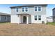 Backyard showing a two-story home with sliding glass door to covered porch and detached garage at 312 Castle Dr, Lake Alfred, FL 33850