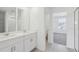 Bright bathroom features double sinks and a shower behind glass doors at 312 Castle Dr, Lake Alfred, FL 33850