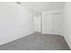 Neutral bedroom featuring soft gray carpet and a closet with sliding doors at 312 Castle Dr, Lake Alfred, FL 33850