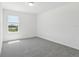 Carpeted bedroom features a window for natural light at 312 Castle Dr, Lake Alfred, FL 33850
