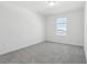 Bright, carpeted bedroom featuring a window for natural light at 312 Castle Dr, Lake Alfred, FL 33850