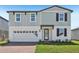 Two-story home with a combination of vertical and horizontal siding, a brick driveway, and an attached garage at 312 Castle Dr, Lake Alfred, FL 33850