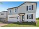 Two-story home with a combination of vertical and horizontal siding, a brick driveway, and an attached garage at 312 Castle Dr, Lake Alfred, FL 33850