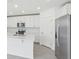 Bright white kitchen features stainless steel appliances and a large kitchen island at 312 Castle Dr, Lake Alfred, FL 33850